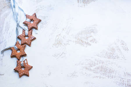Gingerbread cookies star shaped hanging on the ribbon over wooden backgroundの写真素材