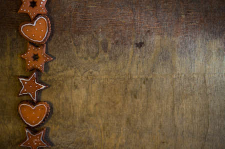 Gingerbread cookies star and heart  shaped  over wooden backgroundの写真素材