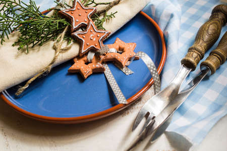 Christmas table setting with vintage silverware and gingerbread   on rustic plateの写真素材