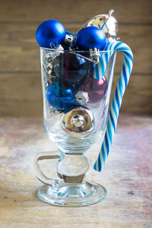 Christmas time decorations with balls and christmas candy on old wooden backgroundの写真素材