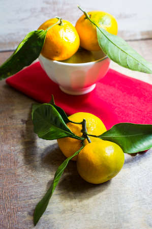 ripe tangerine with green leaves on the rustic backgroundの写真素材