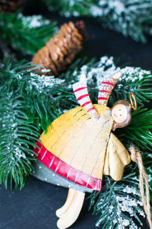 Christmas time interior decorations on the black background with fir tree, pine cones, angels and christmas socksの写真素材