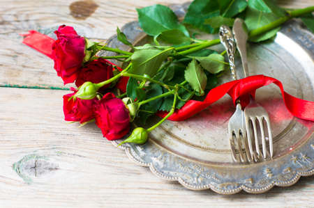Table setting for St. Valentines day with glasses of red wine, present box and red roses  in rustic styleの写真素材