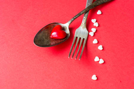 Valentines table setting with vintage silverware and red heart as a decorationの写真素材