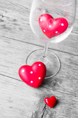 Wine glass with heart shaped gifts for Valentines day on the rustic backgroundの写真素材
