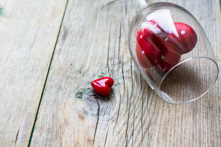 Wine glass with heart shaped gifts for Valentines day on the rustic backgroundの写真素材