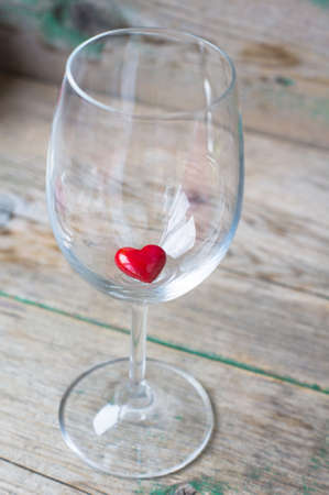 Wine glass with heart shaped gifts for Valentines day on the rustic backgroundの写真素材