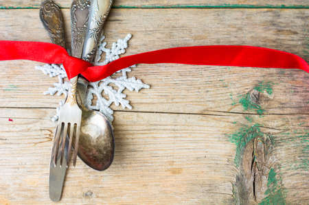 Vintage silverware with red ribbn on rustic backgroundの写真素材