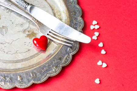 Valentines table setting with vintage silverware and red heart as a decorationの写真素材