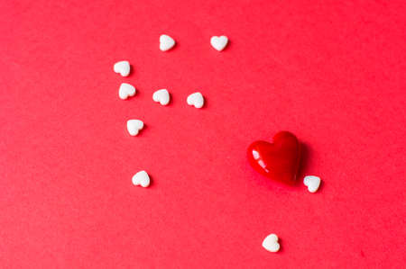 Heart shaped candies on the red background for Valentines day celebrationの写真素材