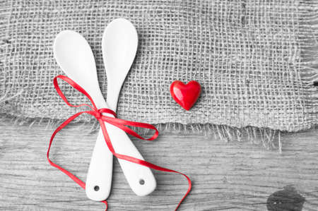 Table setting for St. Valentines day with glasses of wine, present box and red roses  in rustic styleの写真素材