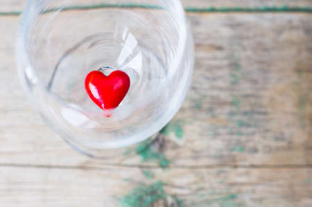 Wine glass with heart shaped gifts for Valentines day on the rustic backgroundの写真素材