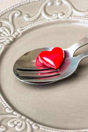 Valentines table setting with vintage silverware and red heart as a decorationの写真素材
