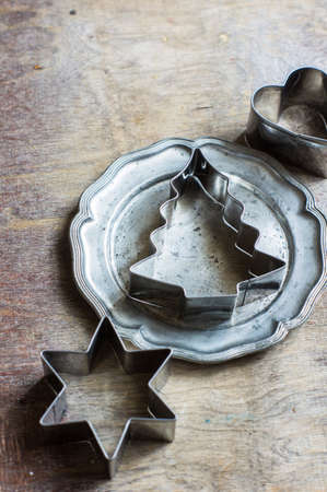 Vintage plate with christmas time cookies cutters on rustic backgroundの写真素材