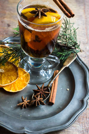 Glass of mulled tea with spices on vintage plateの写真素材