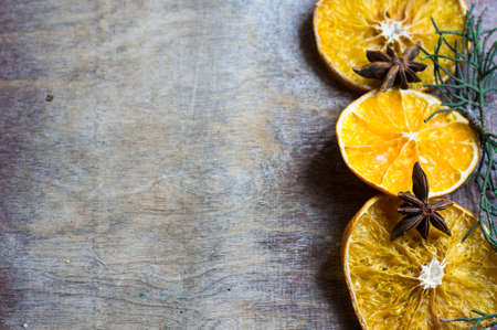 dried oranges, cinnamon and anise spices on rustic christmas background