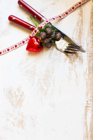 Christmas table setting with vintage silverware and christmas decoration on rustic wooden tableの写真素材