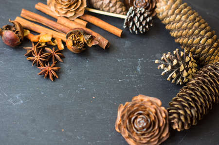 Christmas time spices and pine cones on rustic backgroundの写真素材