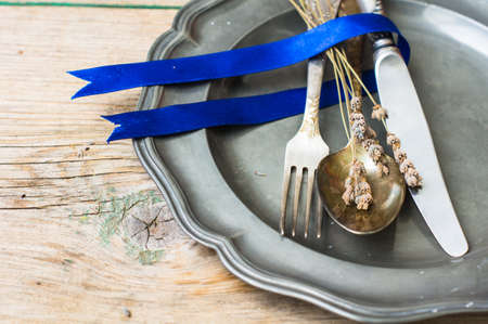 Rustic table setting with vintage plate and silverware with lavender