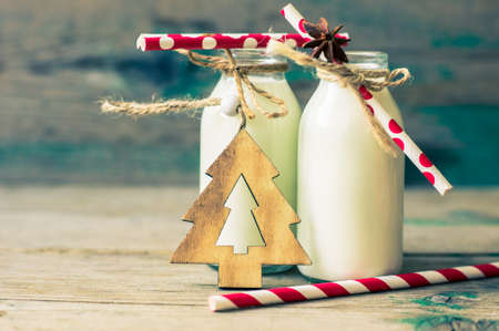Vintage style bottles with milk and spices on rustic background. Toned imageの写真素材