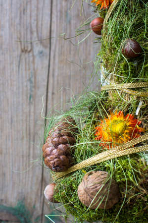Mini christmas tree decorated with cones and  nuts on rustic background