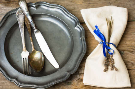 Rustic table setting with vintage plate and silverware with lavenderの写真素材