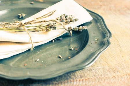 Rustic table setting with vintage silverware and plate with dried lavender flowers. Toned imageの写真素材