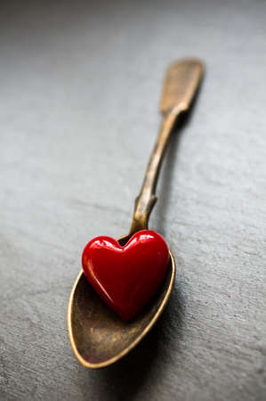 Vintage silverware and heart on rustic wooden background