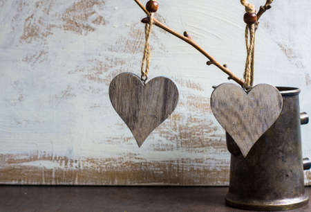 Bright color herts on the tree branch in a jar on rustic background for St. Valentines day...