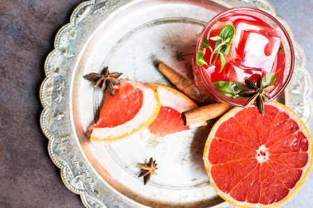 Fresh grapefruit cocktail with cinnamon and anise star spices on rustic backgroundの写真素材