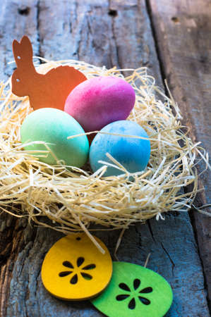 Easter eggs in a nest on rustic background