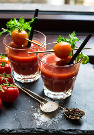 Fresh tomato juice with cherry tomatoes and chili pepper on rustic backgroundの写真素材
