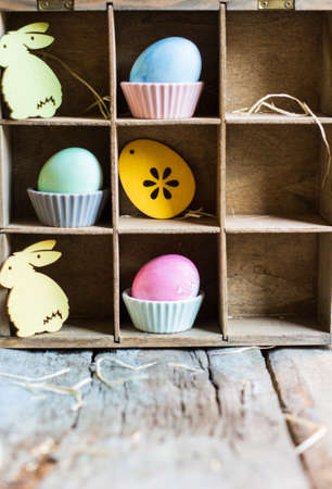 Easter eggs in a vintage box on rustic background