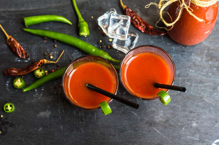 Fresh tomato juice with cherry tomatoes and chili pepper on rustic backgroundの写真素材