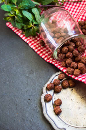 Chocolate breakast flakes with yogurt and mint in vintage glass on rustic background