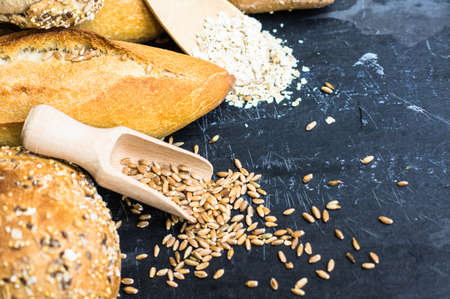 Different tye of bread with wheat spica on dark background