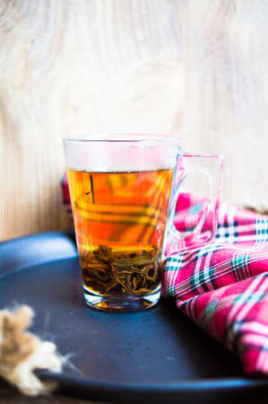 glass of tea with lemon on rustic background