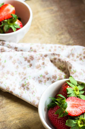 Fresh organic strawberries in vintage plate on  rustic backgroundの写真素材