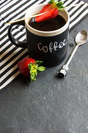 cup of coffee with fresh strawberry on rustic backgroundの写真素材
