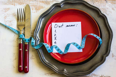 Weight loss concept with vintage plate, silverware and green apple on rustic wooden backgrounf