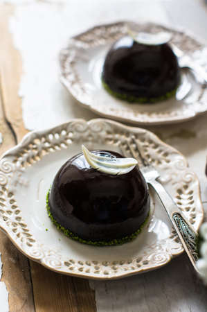 French chocolate mousse mini cake on vintage plate with first spring flowersの写真素材