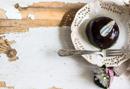 French chocolate mousse mini cake on vintage plate with first spring flowers