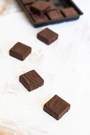 Chocolate candies on the wooden white background