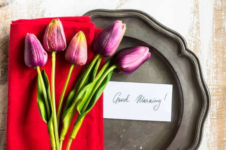 Spring time table setting with tulip flowers and good morning noteの写真素材
