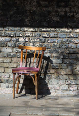 Old wooden chair close to the brick wallの写真素材