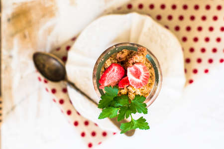 Healthy breakfast granola with strawberry, vintage silverware and glassの写真素材