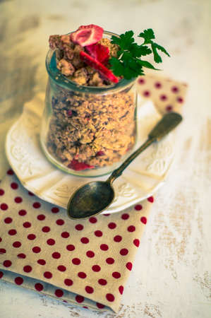 Healthy breakfast granola with strawberry, vintage silverware and glassの写真素材