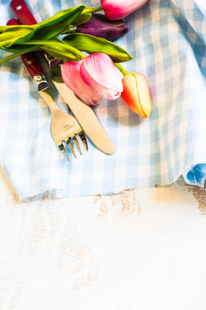 spring rusty table settings with fresh tulips, napkin and silverwareの写真素材