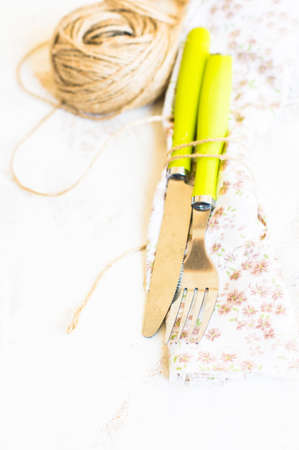 Rustic table setting with vintage silverware and bright color napkin