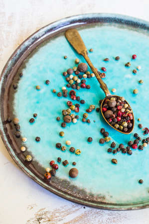 Different sorts of pepper grain on the bright turquoise plateの写真素材
